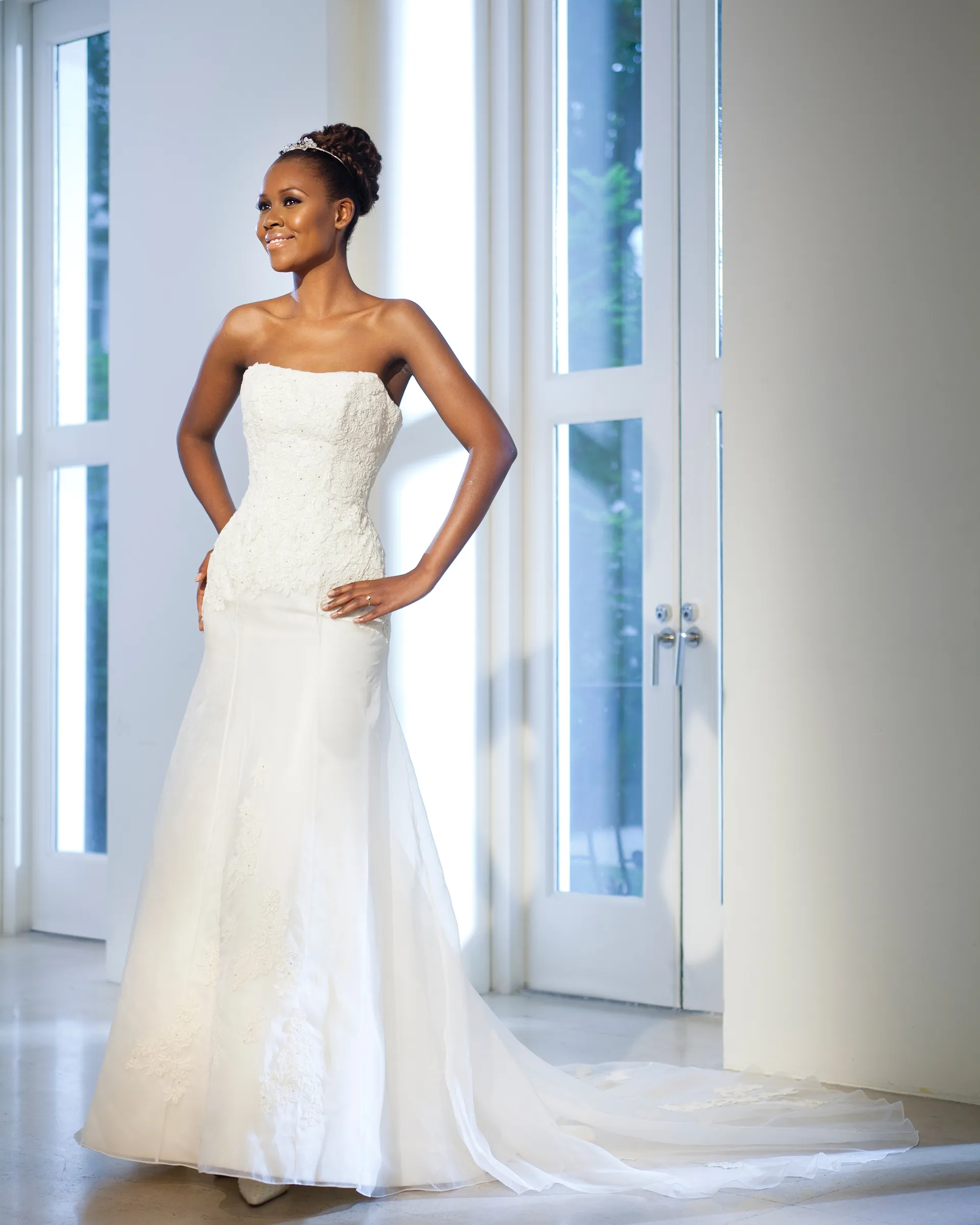Alexandria without the chemise, hands on hips: the strapless lace bodice and an organza skirt over zibeline, sweeping out into a chapel train.