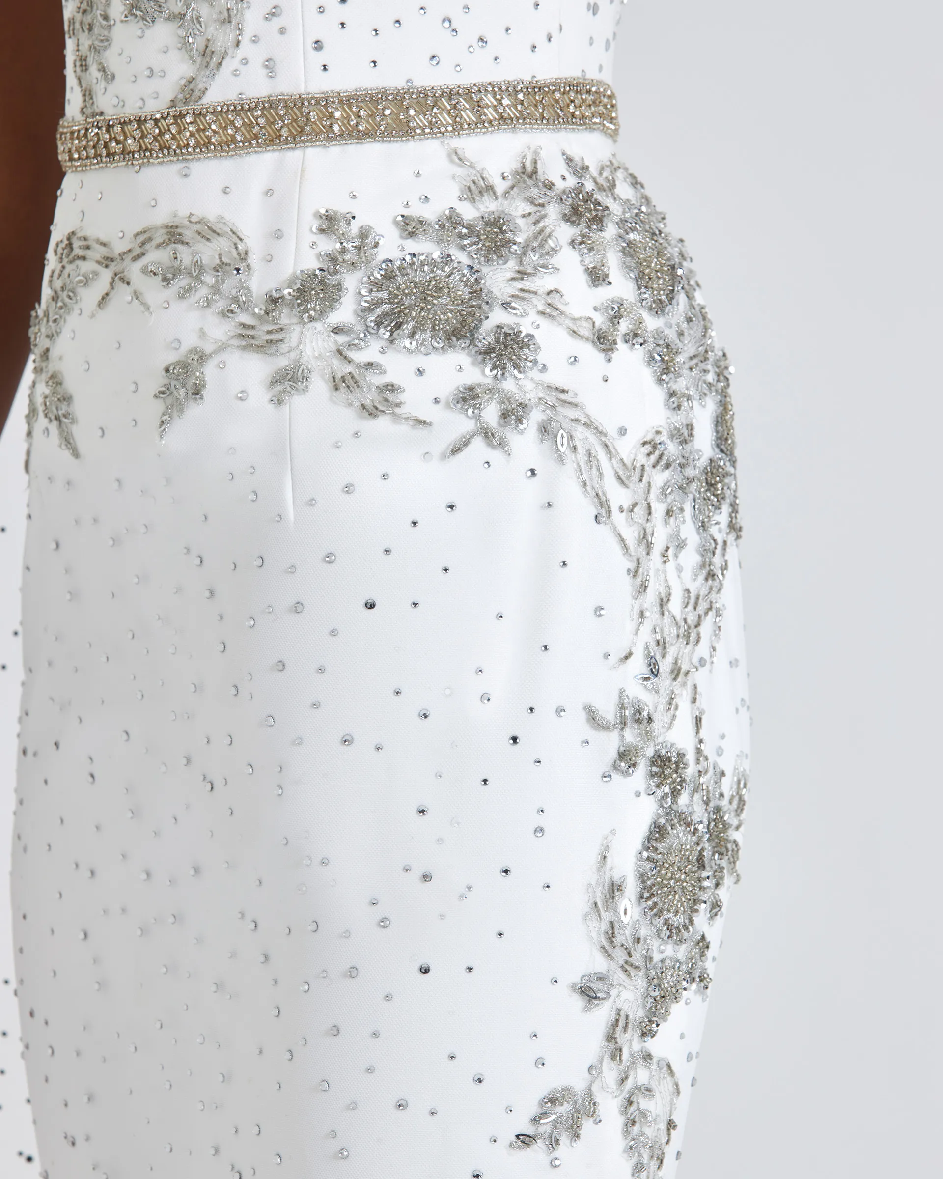 Ashake, side detail: the beaded waistband and silver floral appliqués trailing over the hip, the skirt scattered with crystals.