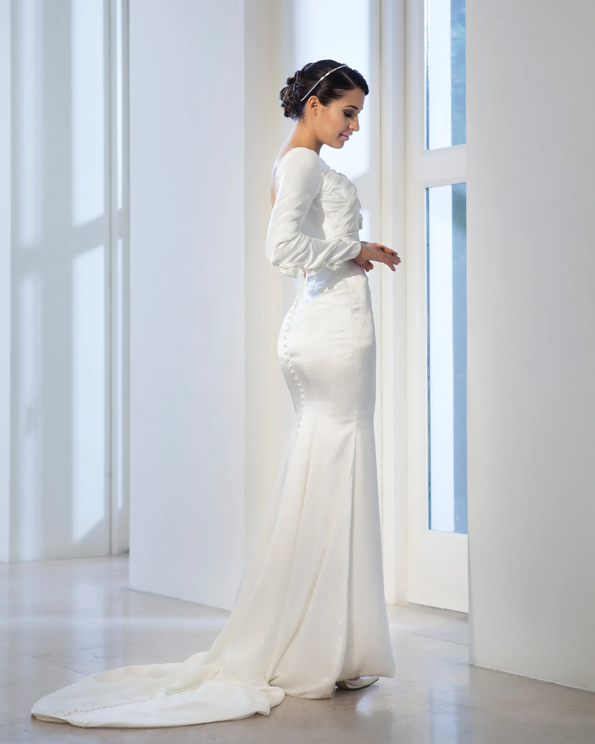 Aurelie, side: long satin sleeves, covered buttons running down the back of the fitted skirt, and the fishtail falling into a train.