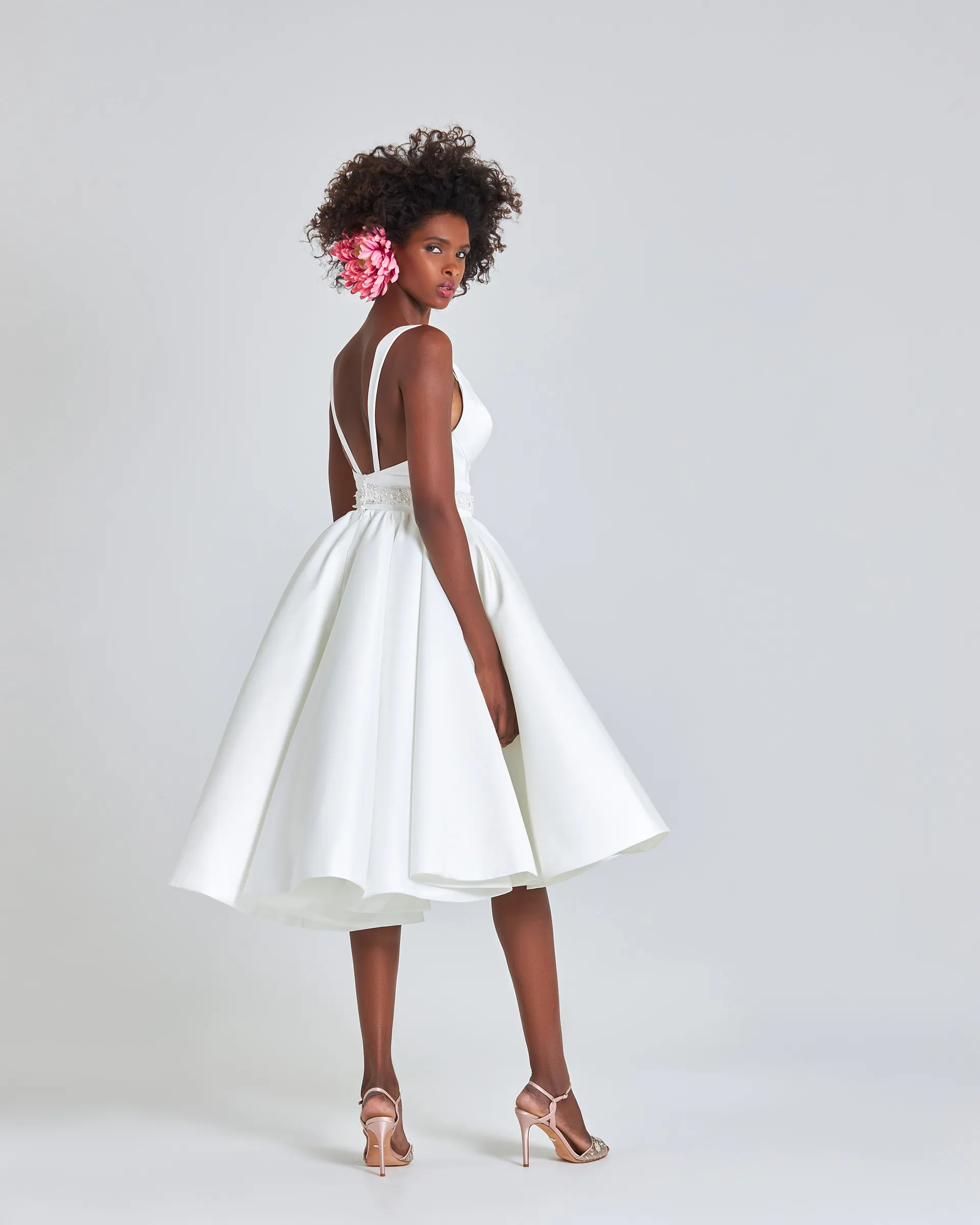 Ayo, back: straps run from the shoulders to the cinched waistband across an open back, and the skirt flares to the calf.