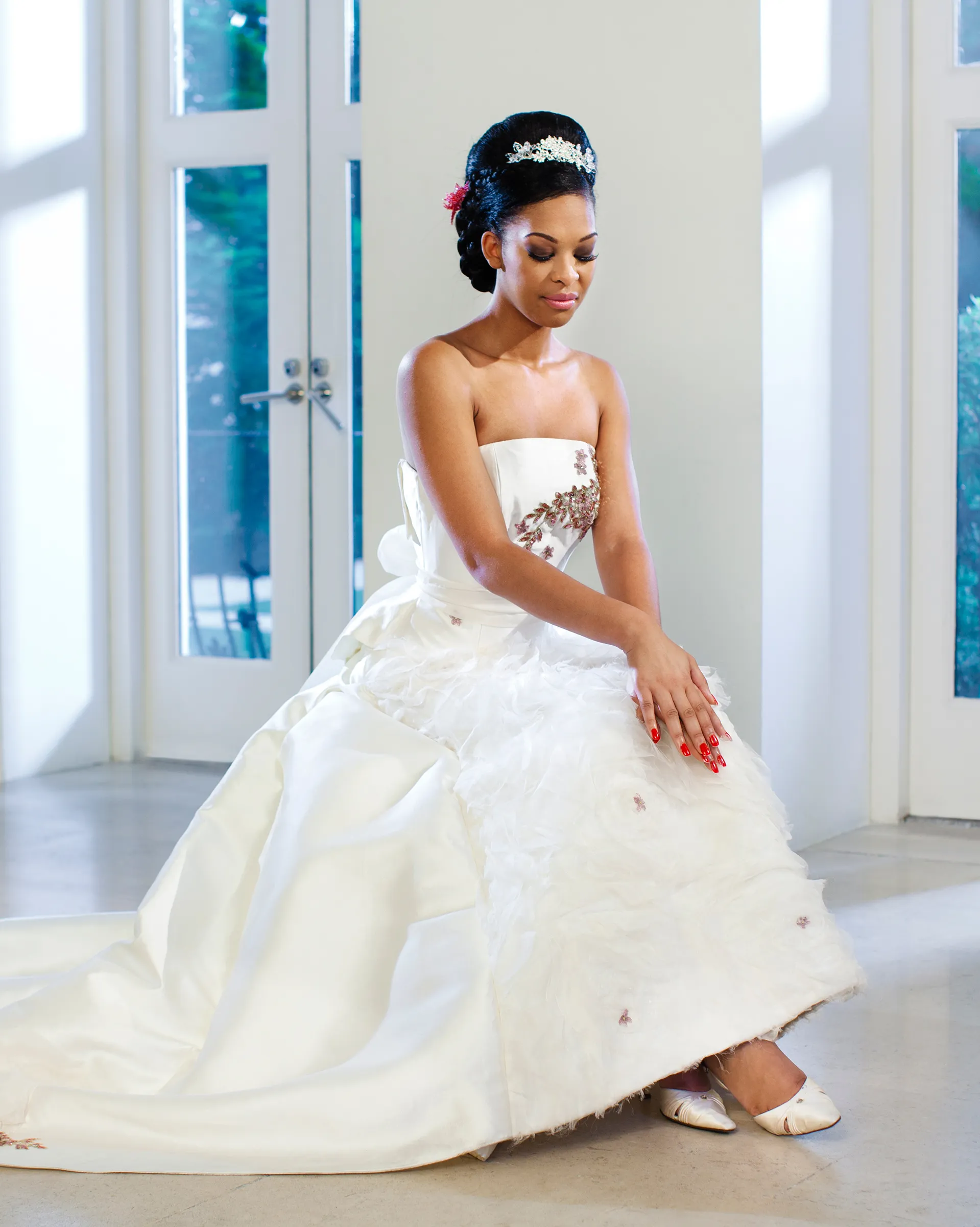 Ekatarina, seated, eyes lowered: pink- and crystal-beaded appliqués on the strapless bodice, scattered over the ruched organza and the folds of the zibeline overskirt.