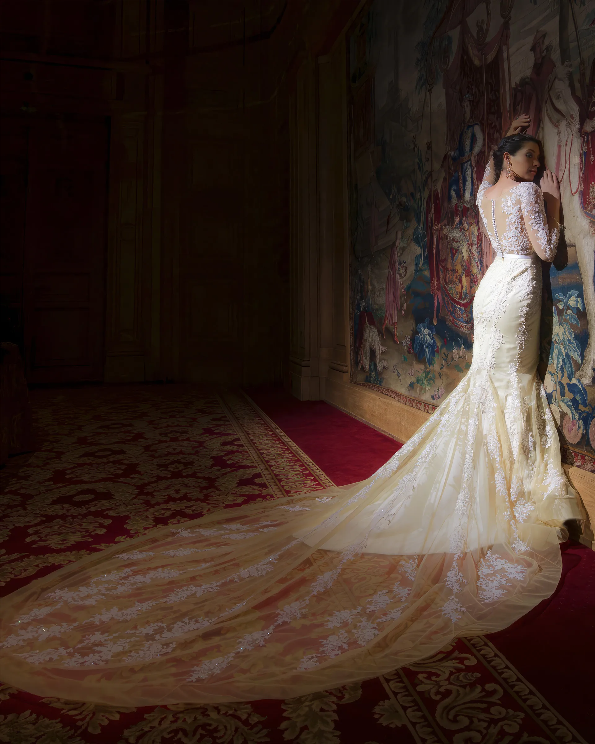 Euterpe leaning against a tapestry in a darkened room, the illusion back and the lace-scattered train lit gold against the shadows.