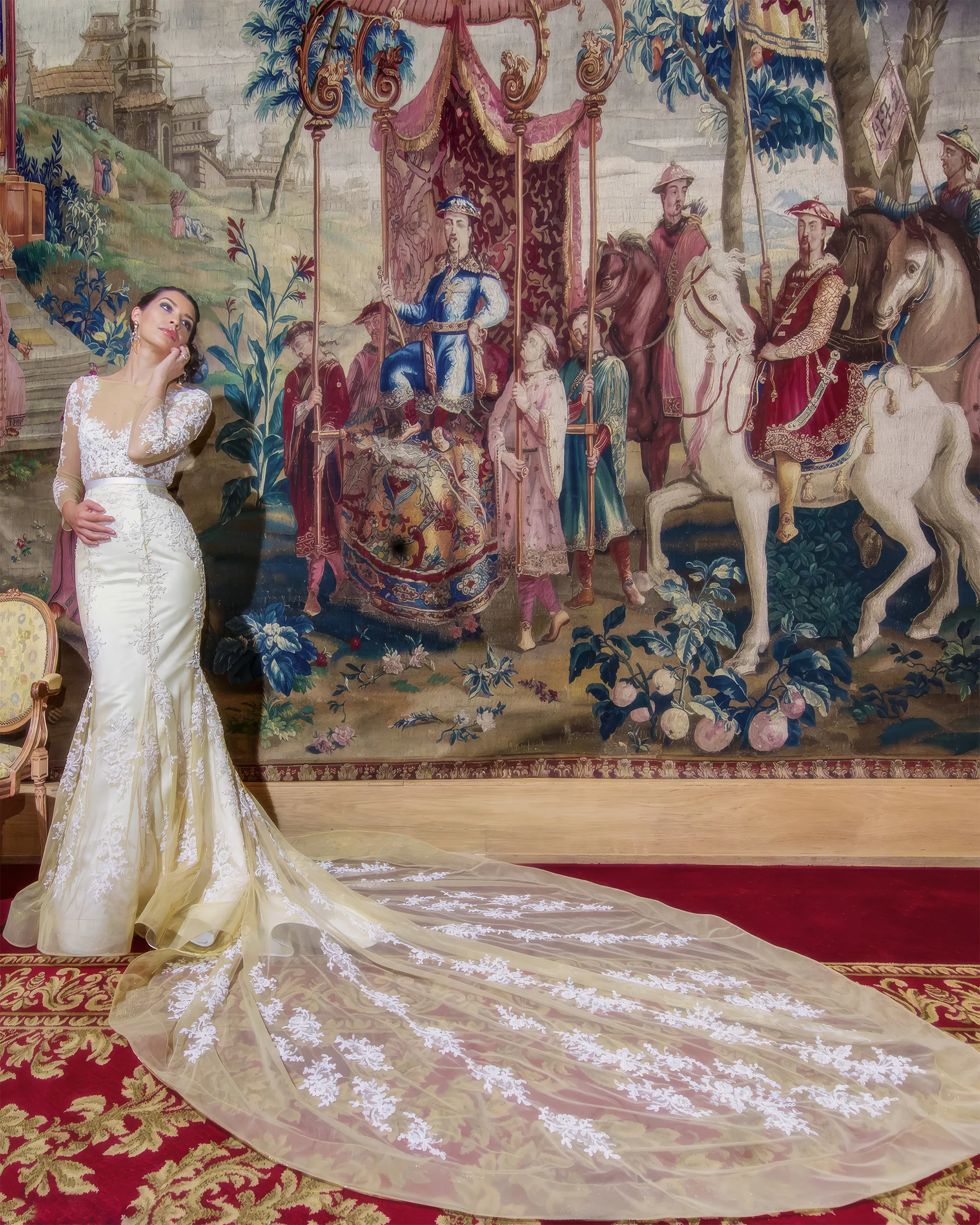 Euterpe before a vast tapestry, the lace-appliquéd tulle overskirt streaming far across the red carpet into a cathedral train.