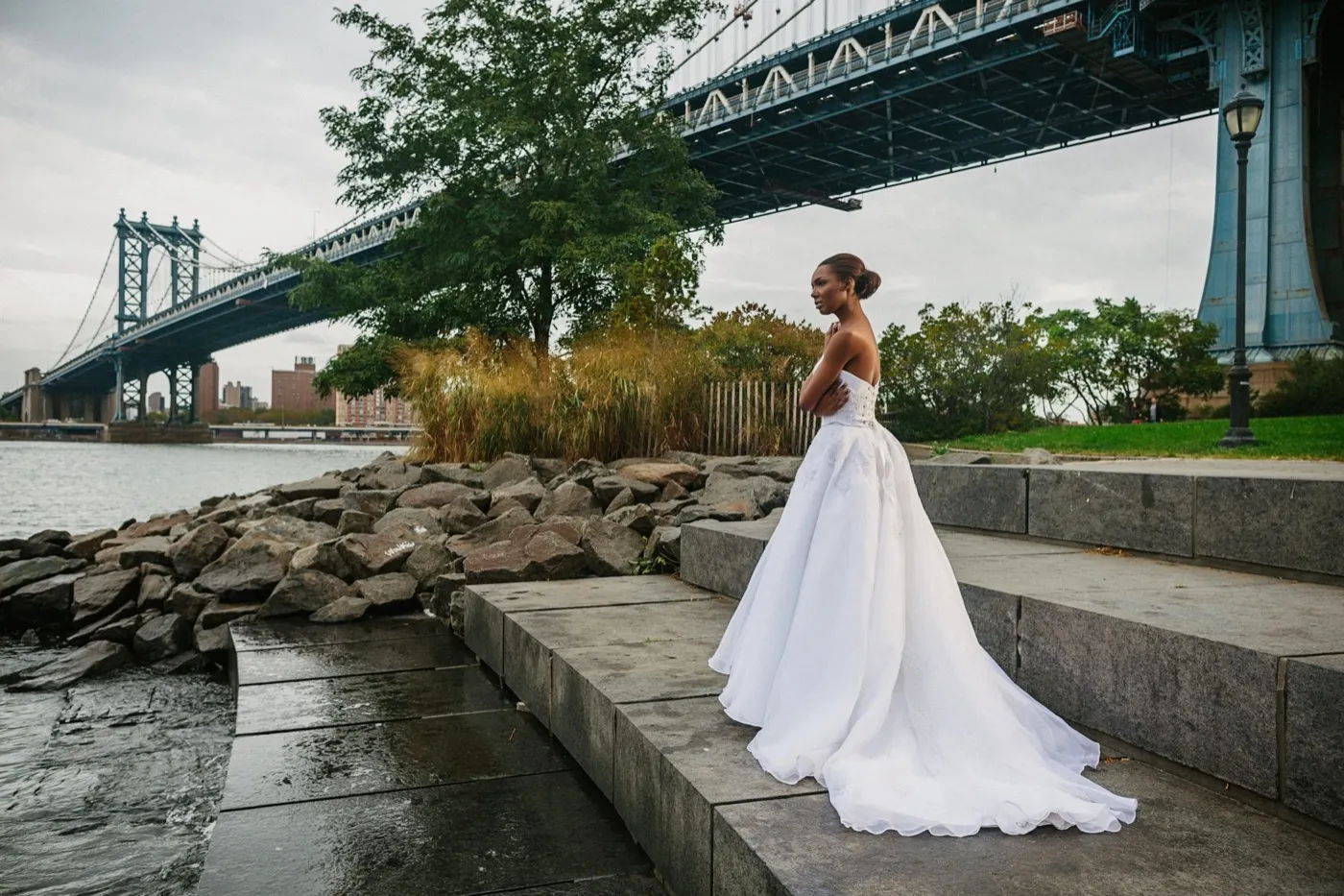 A bride in a strapless Kosibah couture ballgown on the riverside steps beneath the Manhattan Bridge.