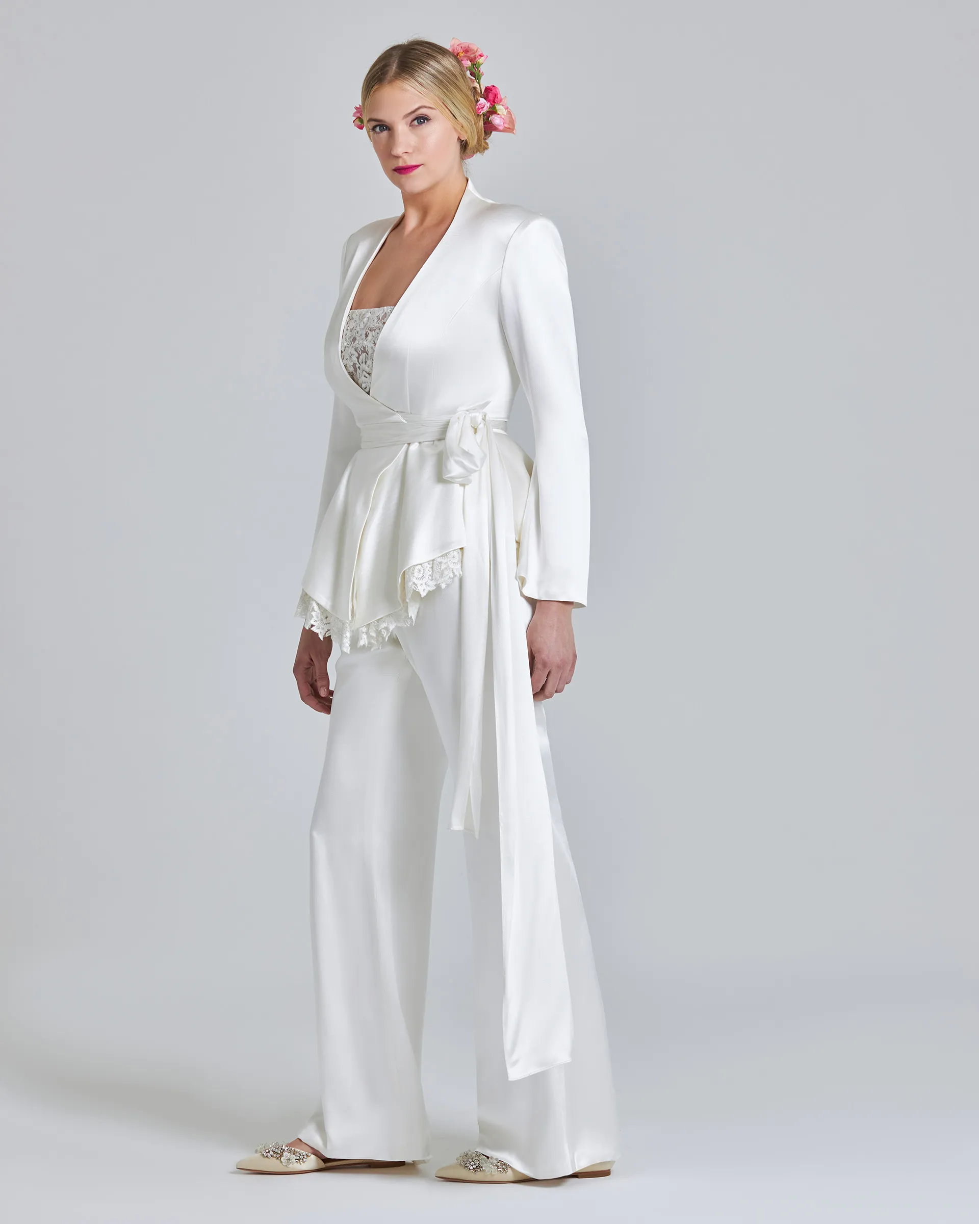 Kemi, side: the built-up collar and padded shoulder, the sash ties falling to the knee, and scalloped lace showing beneath the peplum.