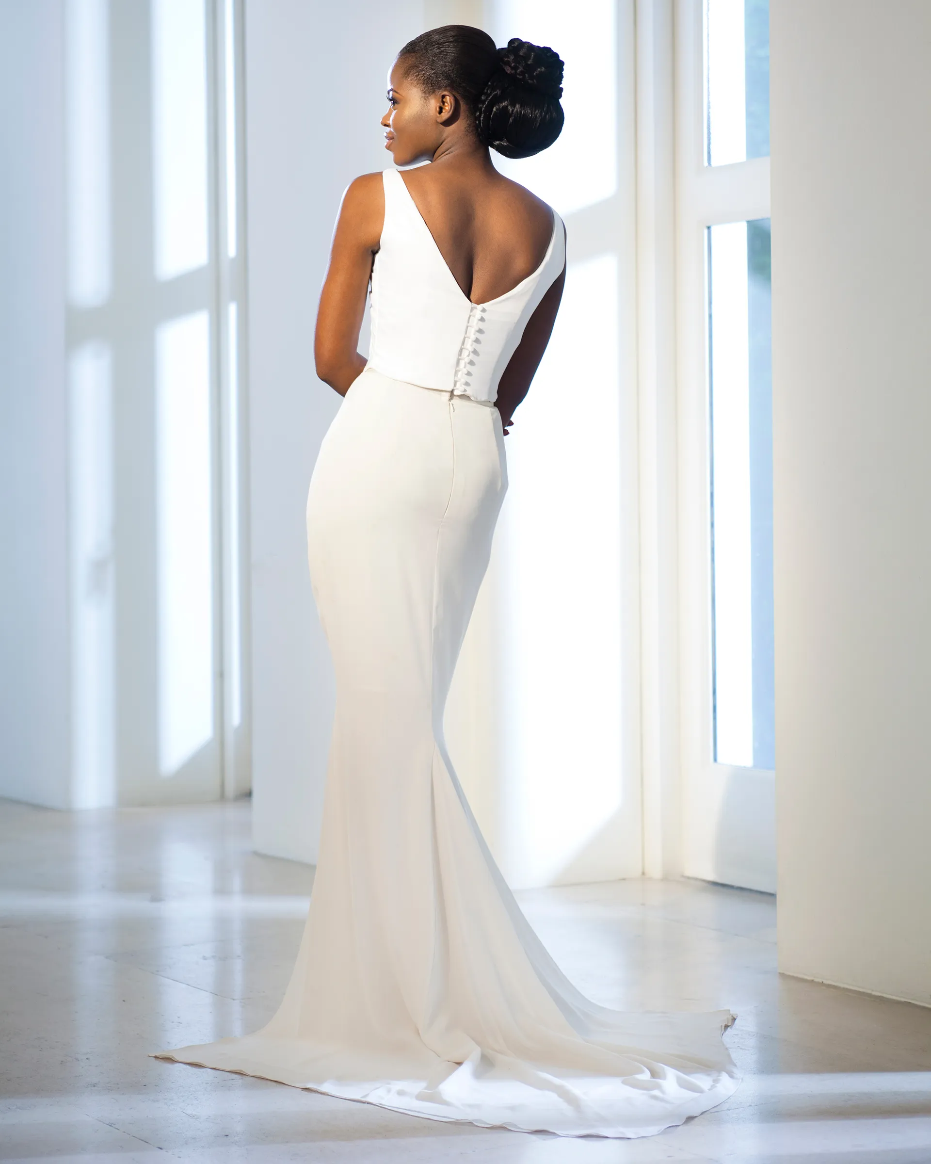 Margot, back: a low V-back closed with covered buttons, and the fitted chiffon skirt sweeping into a chapel-length train.