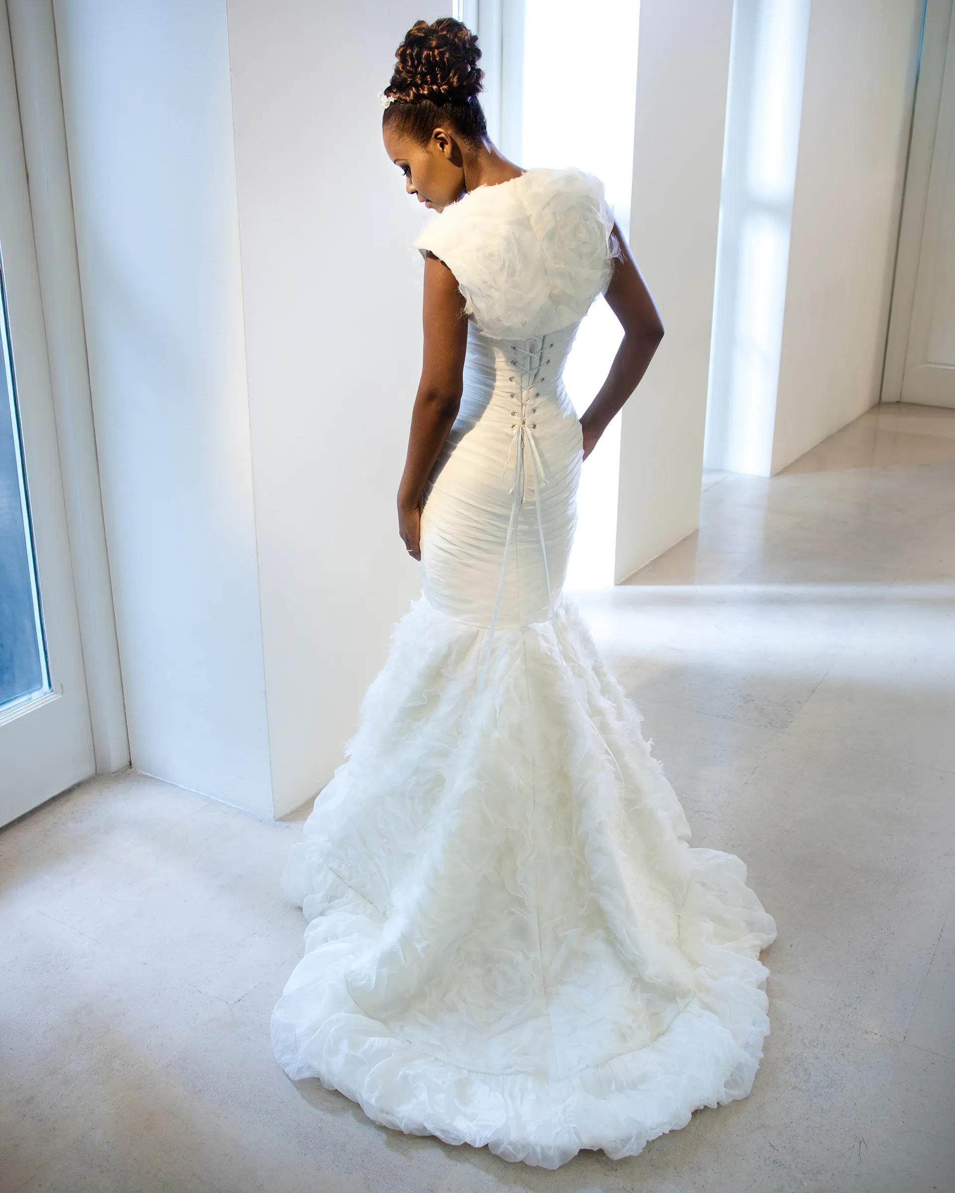 Odette, back: the textured organza bolero over a laced back, and the rose-swirl skirt spreading into a chapel-length train.