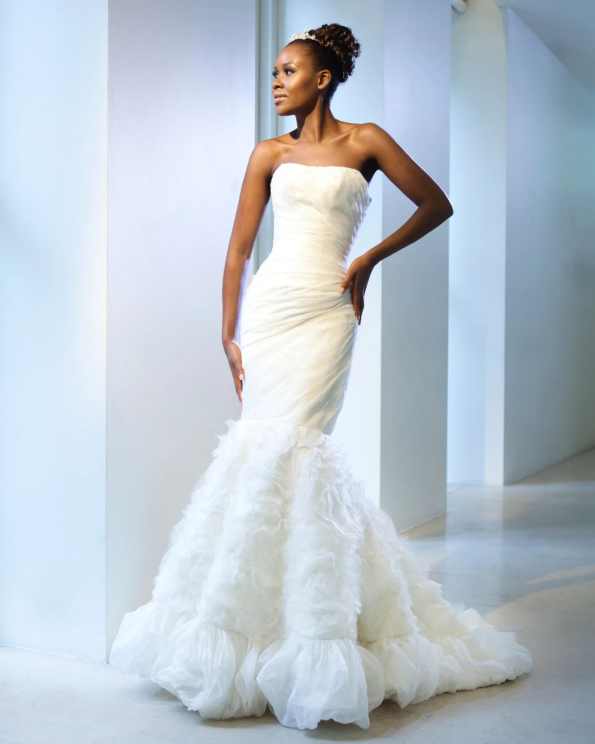 Odette without the bolero: the strapless ruched bodice and a fishtail skirt of textured organza rose swirls, gathered into a puffball hem.