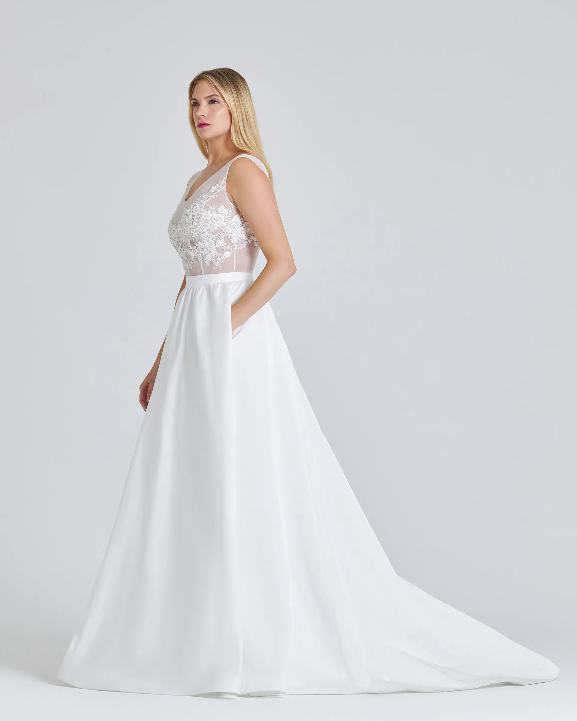 Ronke, side, hand in the side pocket of the softly gathered eco faille skirt, which sweeps back into a short train.