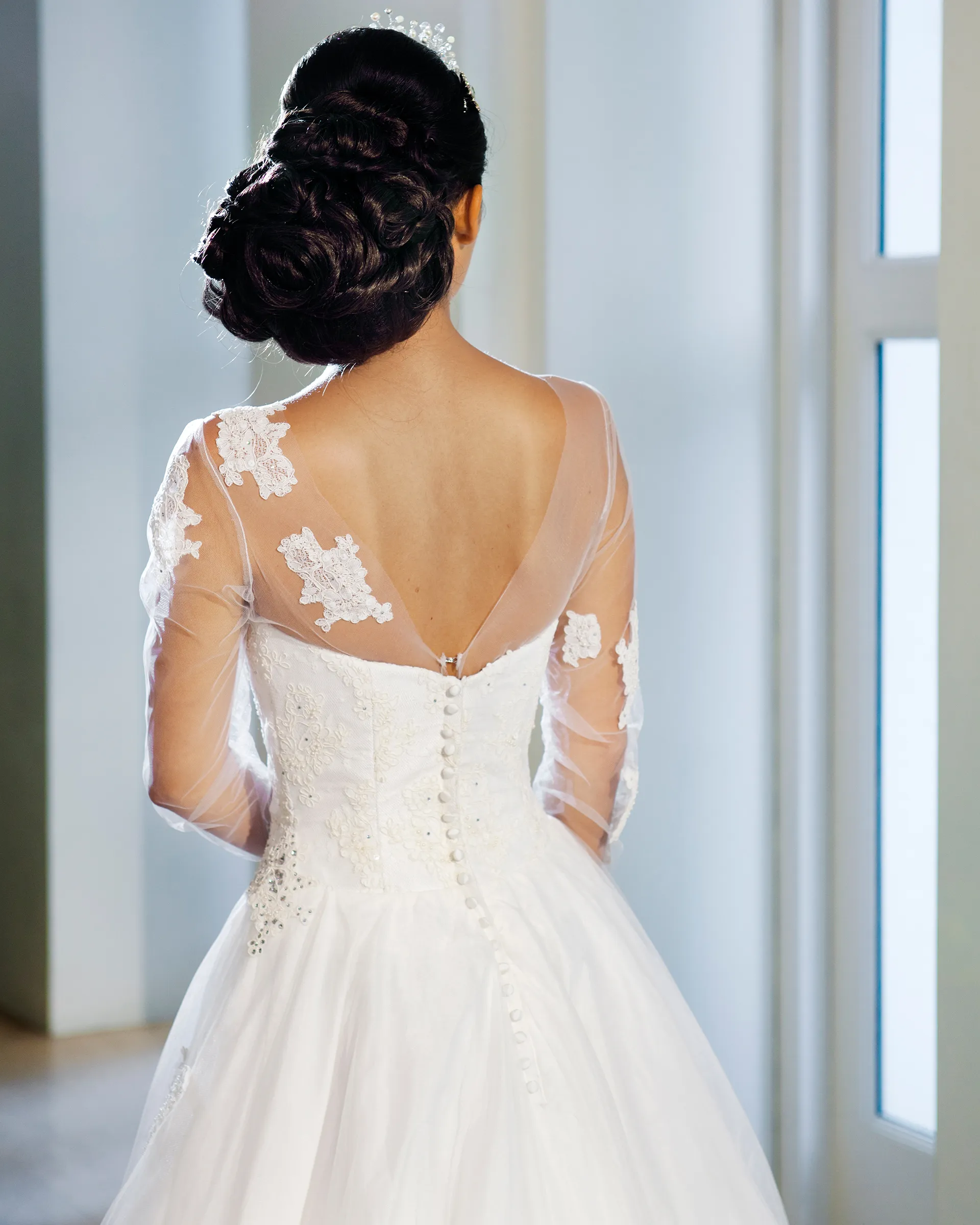 Titania, back detail: a deep V of sheer tulle edged with lace appliqués, over a lace bodice closed with a long line of covered buttons.